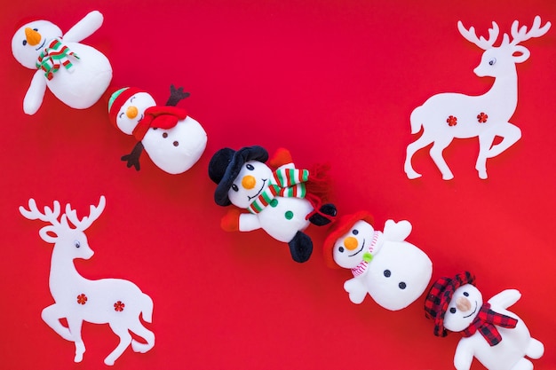 Free Photo small toy snowmen with deer on table