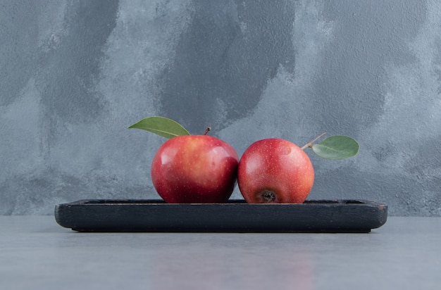 Free photo a small tray with juicy apples on marble .