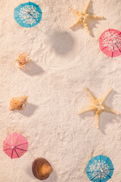 Free Photo small umbrellas with shells on beach