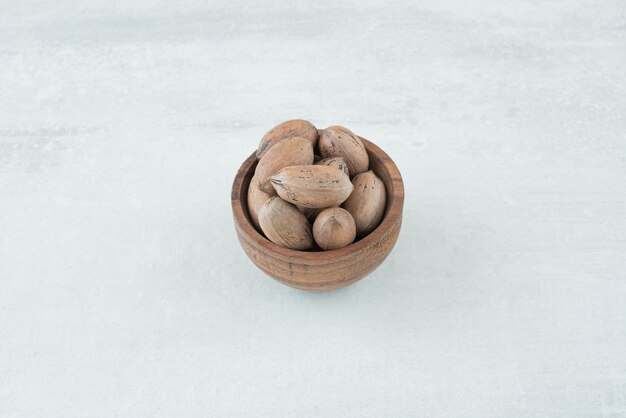 A small wooden bowl of nuts on white background. High quality photo