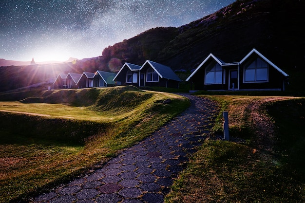 A small wooden church and cemetery Hofskirkja Hof, Skaftafell Iceland. Scenic sunset through tree crowns