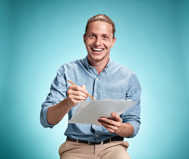 Free photo smart smiling student with great idea holding sheets of paper