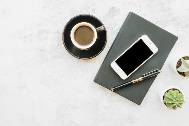 Smartphone and coffee on table with notebook