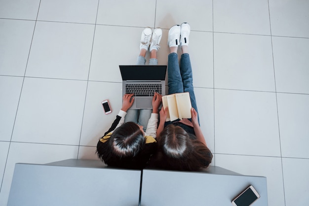 Free photo smartphone, laptop and book. top view of young people in casual clothes working in the modern office