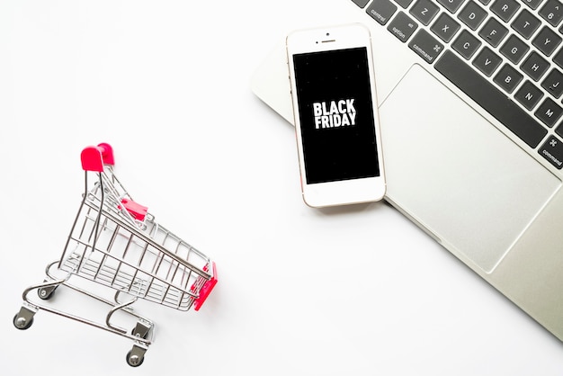 Smartphone with Black Friday inscription on light table 