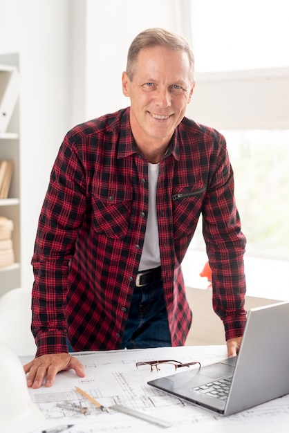 Free photo smiley architect posing at his desk