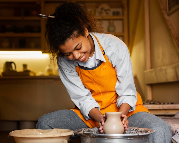 Free Photo smiley artist doing pottery