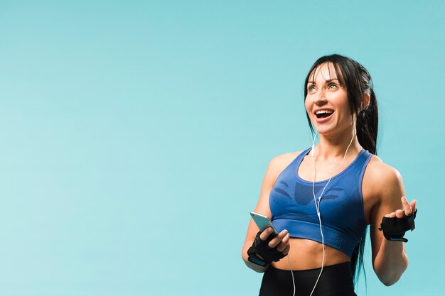 Smiley athletic woman enjoying music in headphones