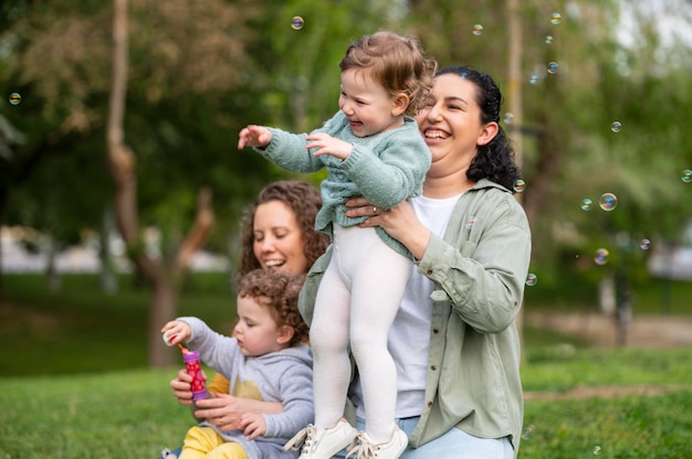 Smiley babies outdoors in the park with lgbt mothers