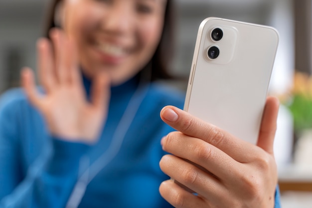 Smiley blurry woman holding smartphone