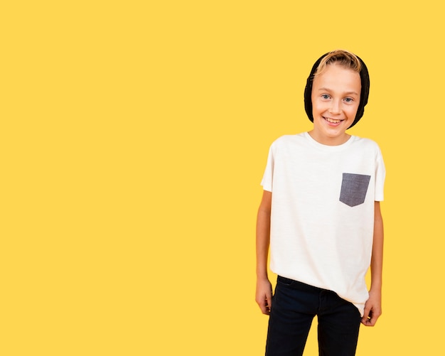 Free photo smiley boy dressed casual on yellow background