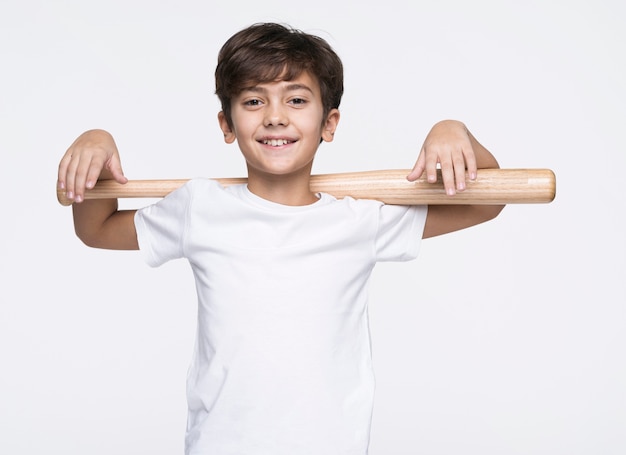 Free photo smiley boy holding baseball bat