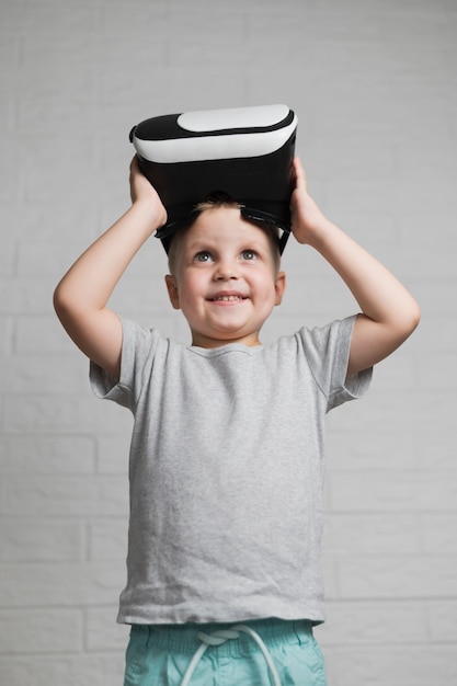 Smiley boy putting on virtual headset