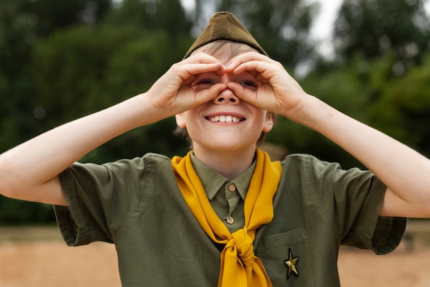 Free Photo smiley boy scout outdoors front view