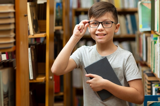 Free photo smiley boy with glasses at library