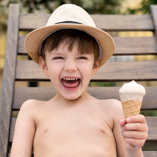 Smiley boy with hat eating ice cream