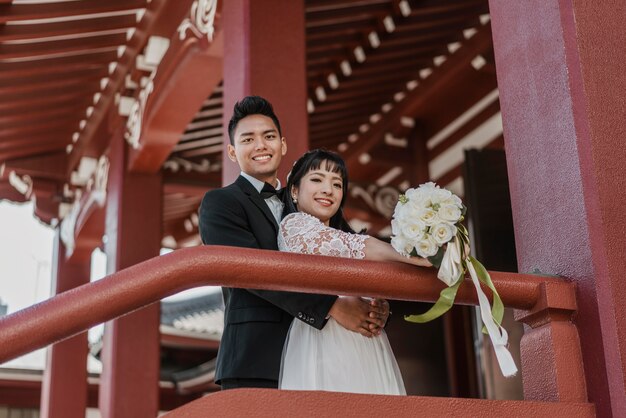 Smiley bride and groom posing together outdoors