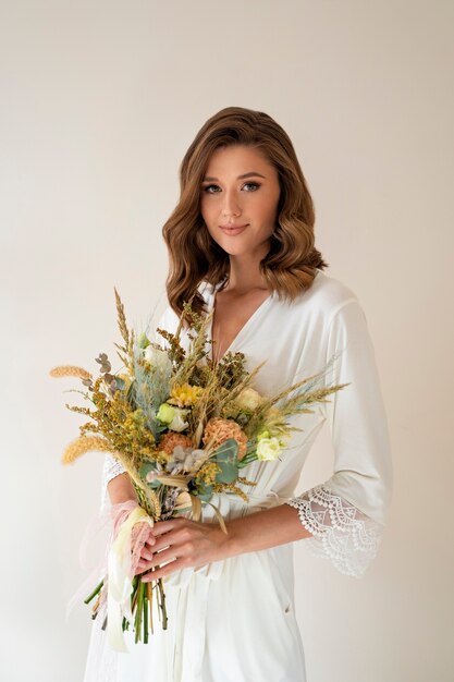 Smiley bride holding flowers medium shot