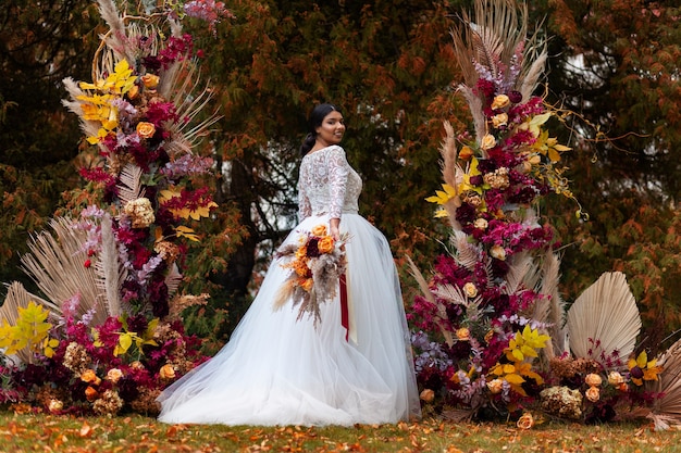 Smiley bride posing with flowers side view