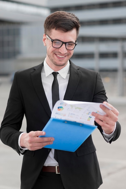 Smiley business man checking clipboard