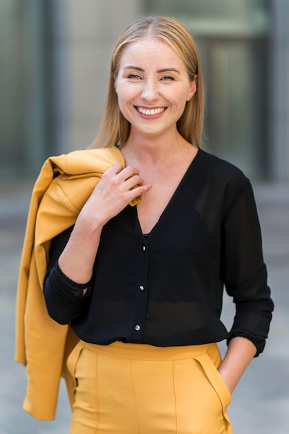 Smiley business woman posing outdoors in suit