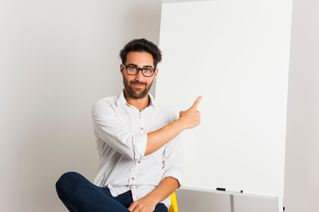 Free photo smiley businessman presenting whiteboard