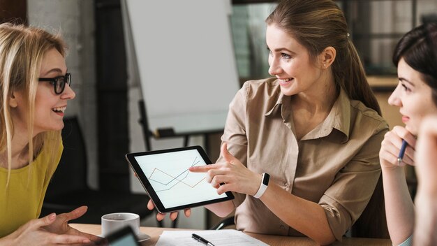 Smiley businesspeople using tablet during a meeting indoors