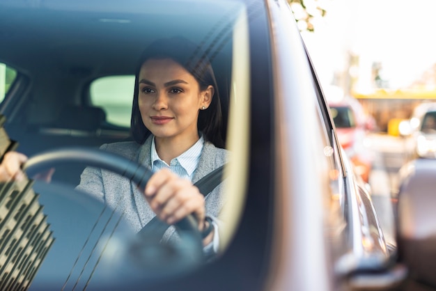 Smiley businesswoman driving her car