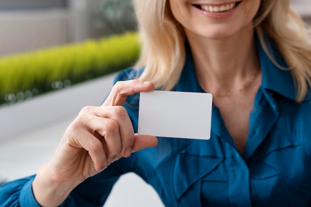 Free Photo smiley businesswoman holding business card