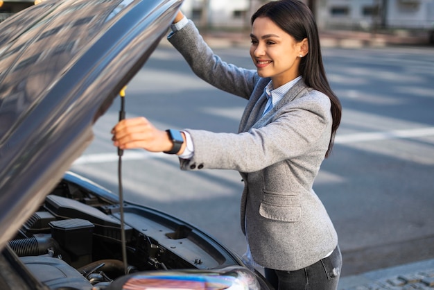 Smiley businesswoman lifting the car's hood