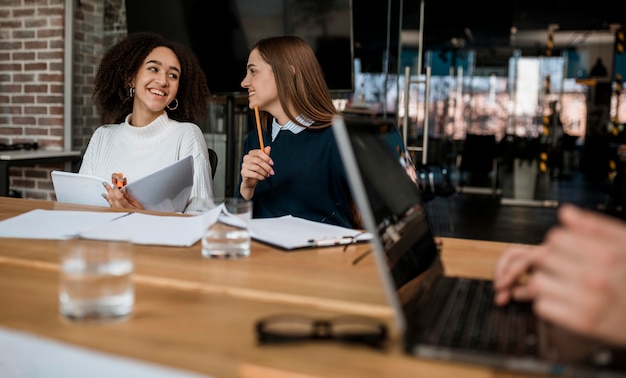 Smiley colleagues talking to each other during a meeting