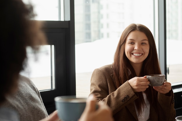 Smiley colleagues with coffee cups at work