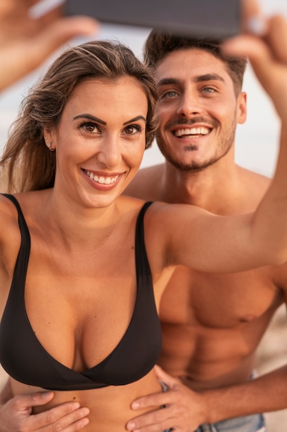 Smiley couple at beach taking selfie