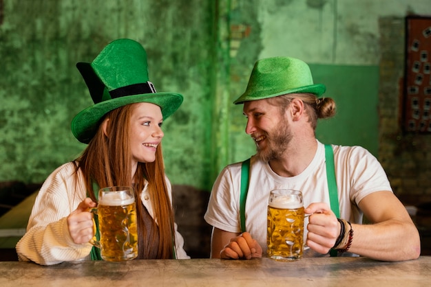 Free photo smiley couple celebrating st. patrick's day at the bar