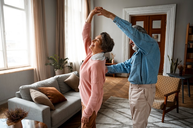 Free photo smiley couple dancing at home side view