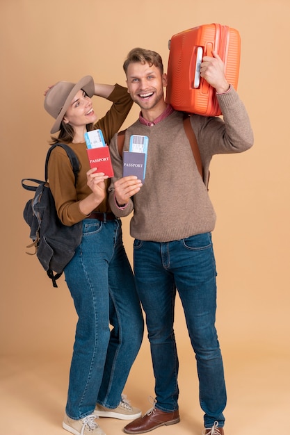 Free photo smiley couple ready for traveling with luggage