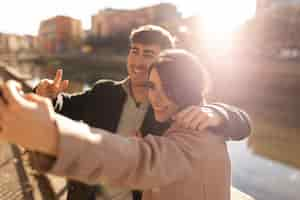 Free photo smiley couple taking selfie medium shot