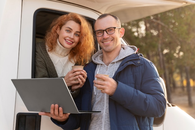 Free photo smiley couple with laptop medium shot