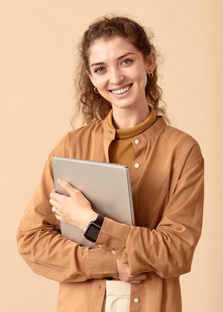 Smiley curly haired lady holding laptop