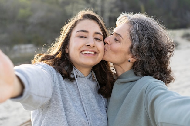 Smiley daughter taking a selfie with her mother outdoors