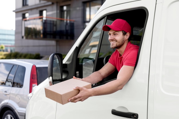 Free photo smiley delivery man with package