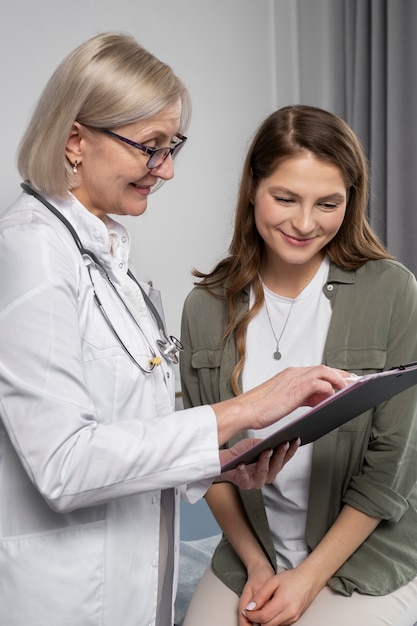 Smiley doctor and patient chatting medium shot