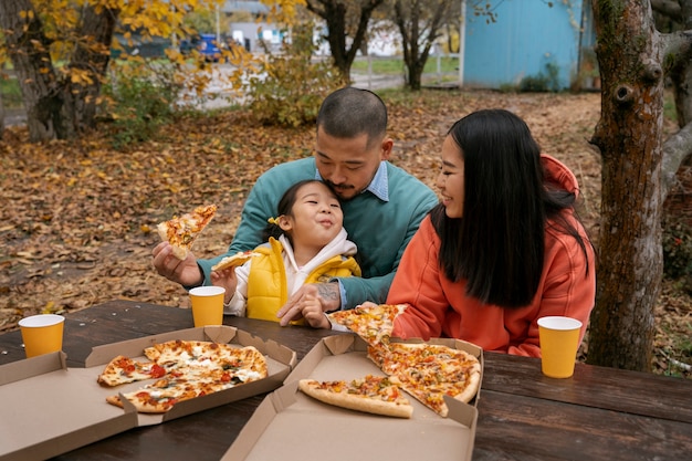 Free photo smiley family with delicious pizza front view