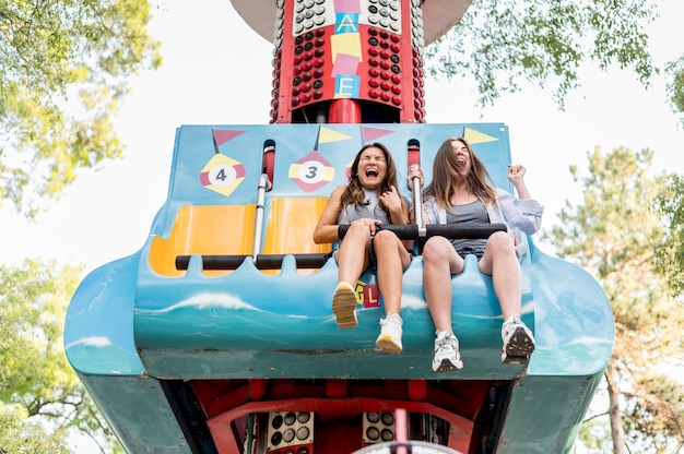 Smiley female friends having fun in the amusement park