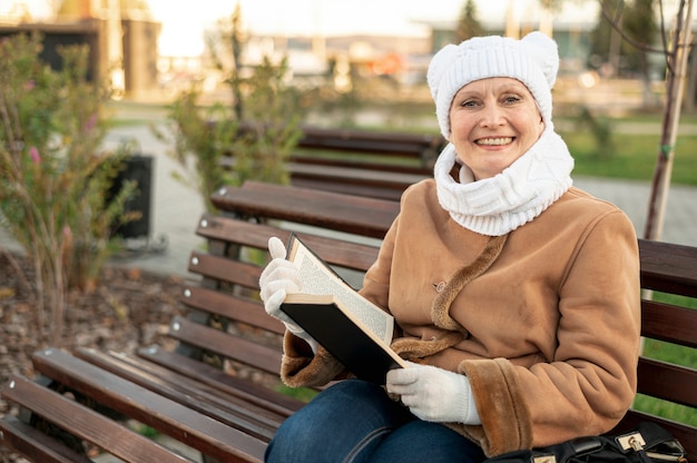 Smiley female sitting on bench and reading