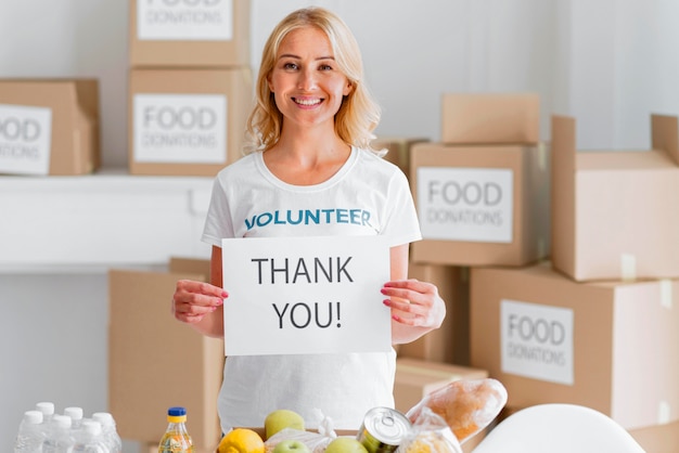 Free Photo smiley female volunteer thanking you for donating food