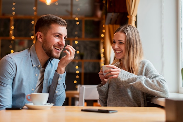 Smiley friends chatting and drinking coffee