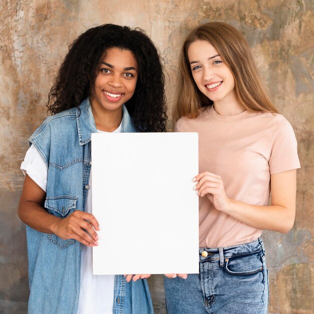 Smiley friends posing together and holding blank placard