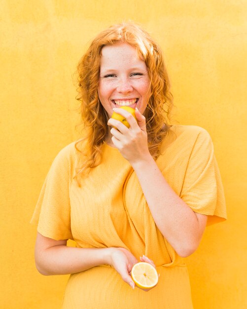 Smiley girl licking lemon