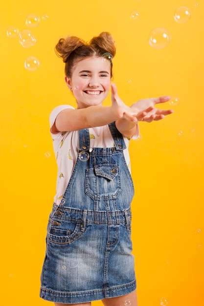 Smiley girl playing with bubbles